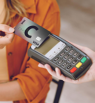 Making a payment with a card using a contactless payment terminal. 