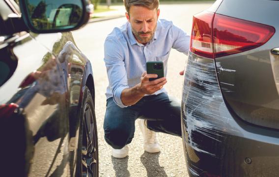 Kambaryje tėtis su dviem vaikais skaito knygą ir rodo jiems kažką puslapyje, visi šypsosi. 