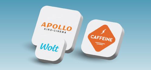Mėlyname fone trys baltos piktogramos: APOLLO, Wolt ir CAFFEINE.