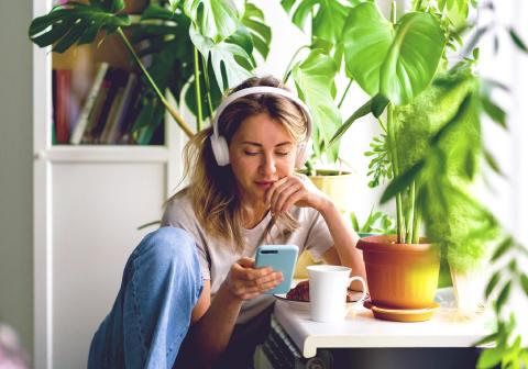 Vyras savo namuose mėgaujasi kava ir žiūri į nešiojamąjį kompiuterį. 