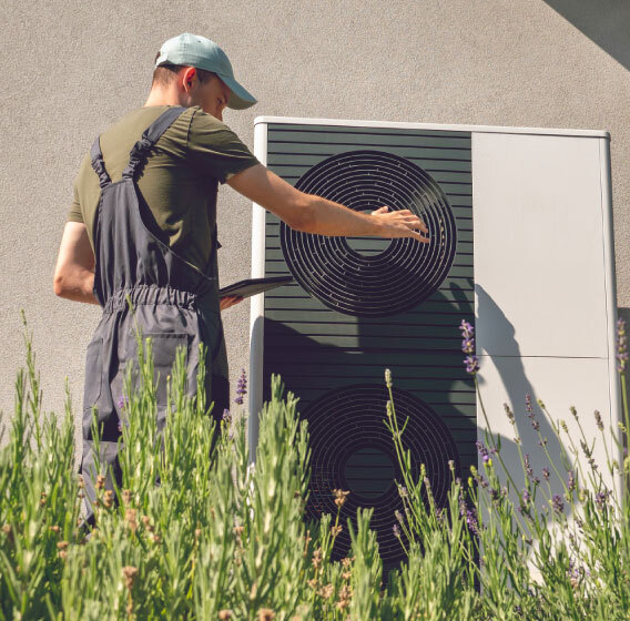 A professional worker is installing a new heat pump for a private house. 